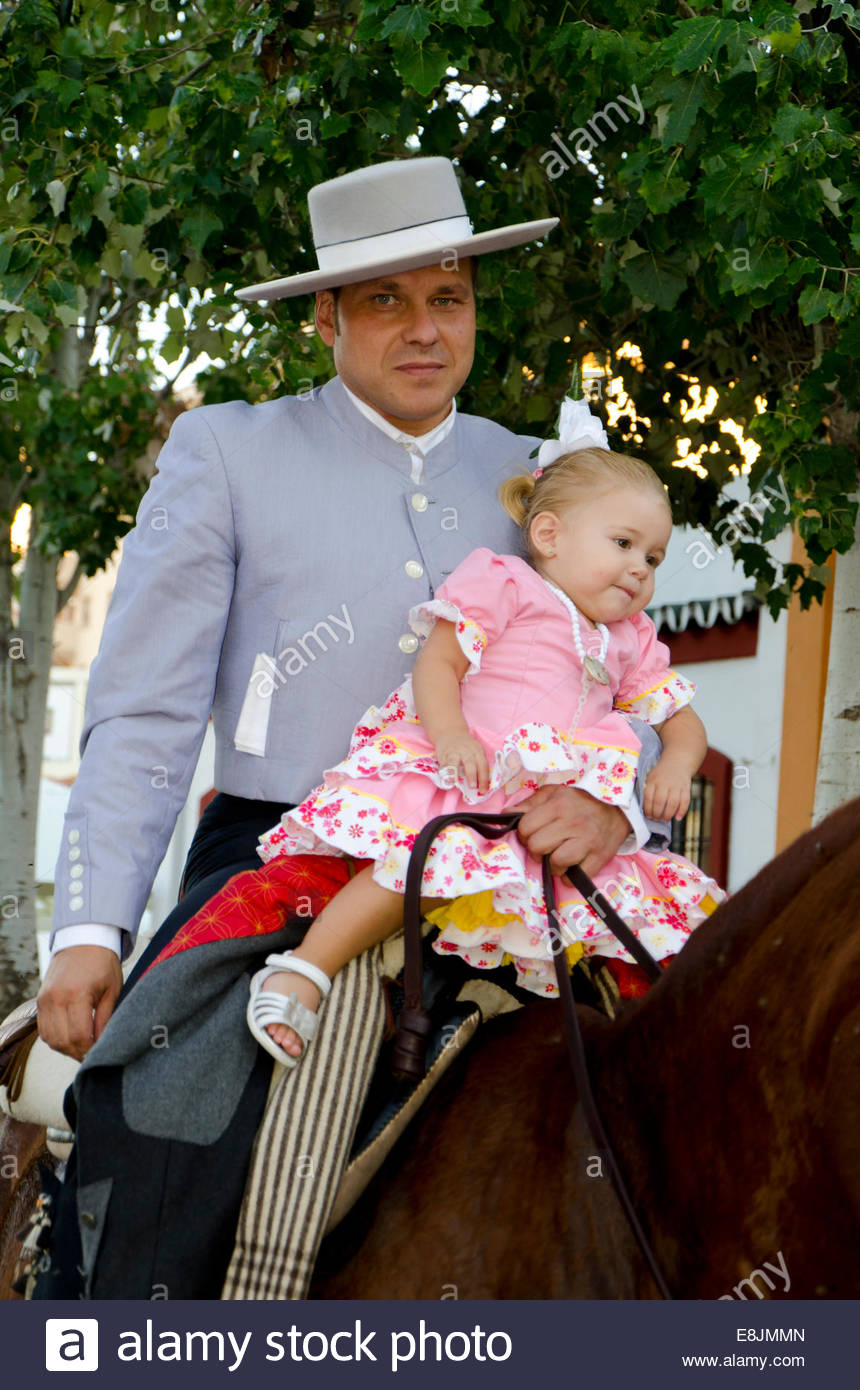 man-on-horse-wearing-cordobes-hat-in-traditional-costume-holding-girl-E8JMMN.jpg